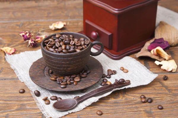 Wooden cup full of coffee with grinders — Stock Photo, Image
