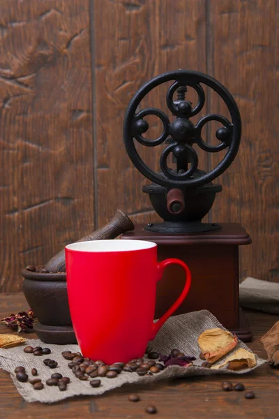 Червона чашка і шліфувальна машина на дерев'яному фоні — стокове фото