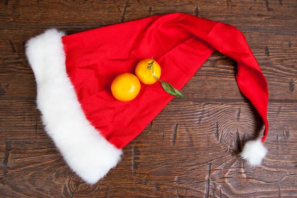 Bir Noel şapka iki mandalina — Stok fotoğraf