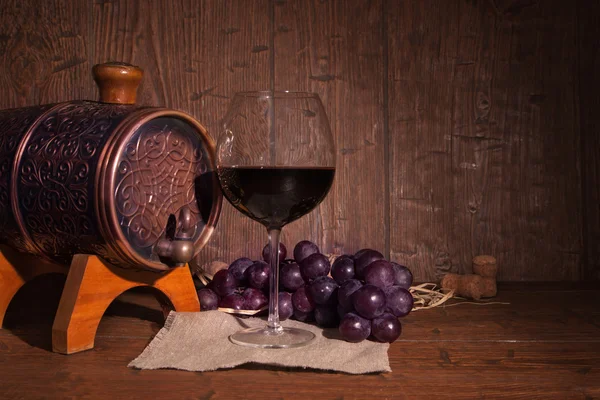 Glas Rotwein und Fass auf rustikalem Holztisch — Stockfoto