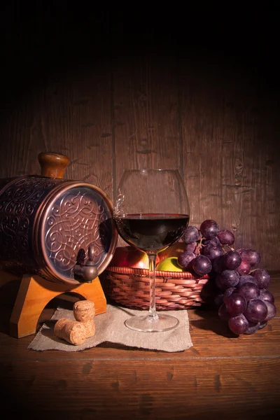 Glas rode wijn en vat op rustieke houten tabel — Stockfoto