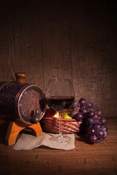 Pohár vörös bor és a rusztikus fa asztali nyomdák hordó — Stock Fotó