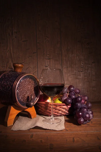 Glas Rotwein und Fass auf rustikalem Holztisch — Stockfoto