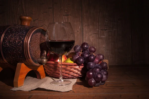 Glas rode wijn en vat op rustieke houten tabel — Stockfoto