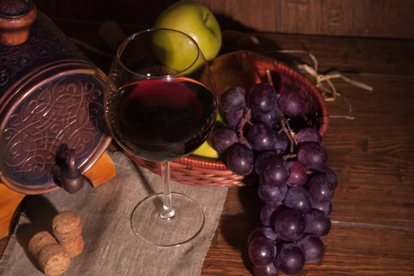 Bicchiere di vino rosso e botte su tavola di legno rustico — Foto Stock