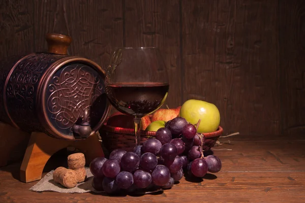 Glas rode wijn en vat op rustieke houten tabel — Stockfoto