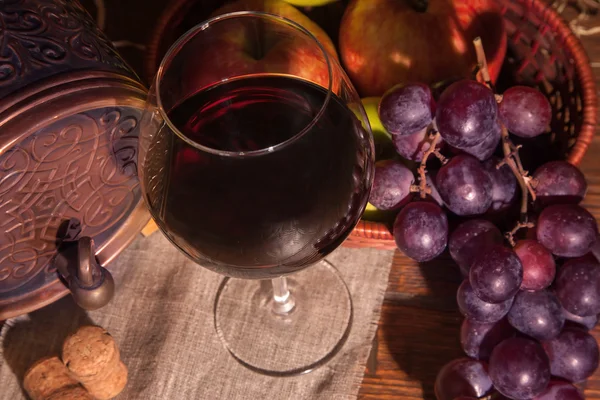 Glas Rotwein und Fass auf rustikalem Holztisch — Stockfoto