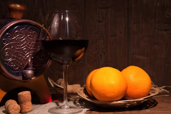Glas Rotwein und Fass auf rustikalem Holztisch — Stockfoto