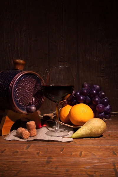 Glas rode wijn en vat op rustieke houten tabel — Stockfoto
