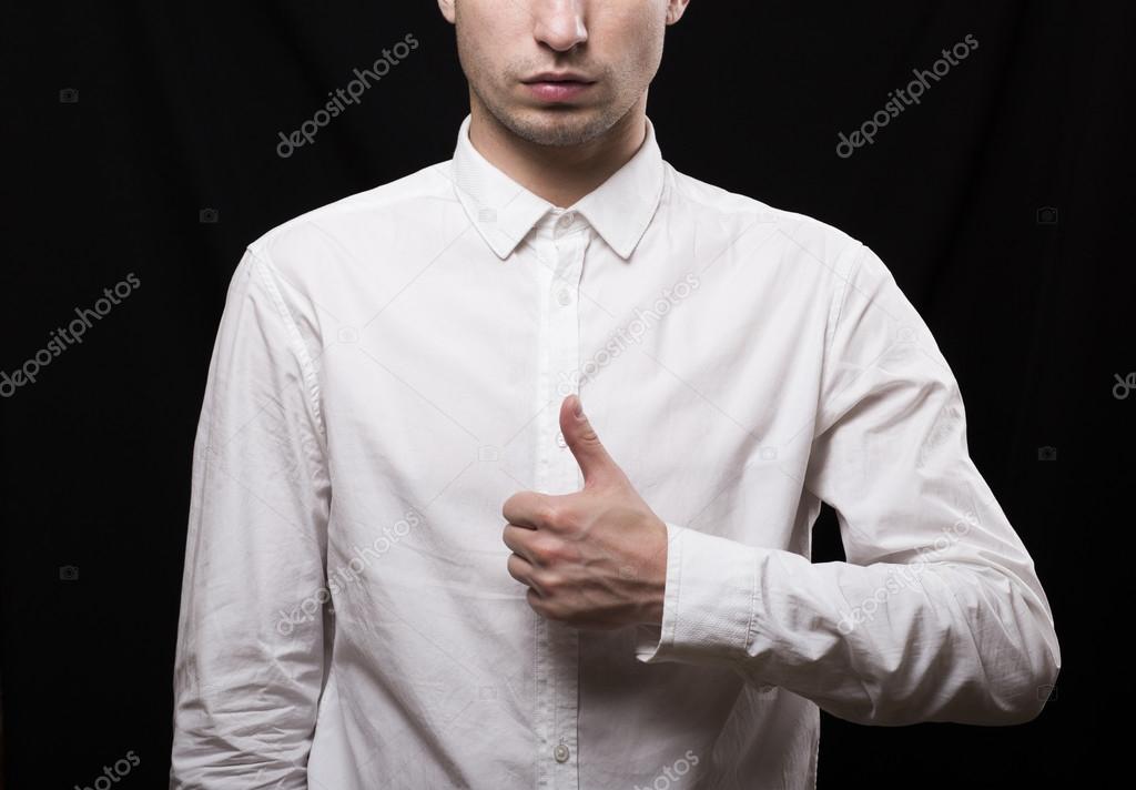 portrait of a young man in a white shirt on a black background