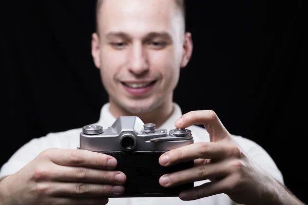 Szczęśliwy młody mężczyzna fotografuje siebie na stary aparat — Zdjęcie stockowe