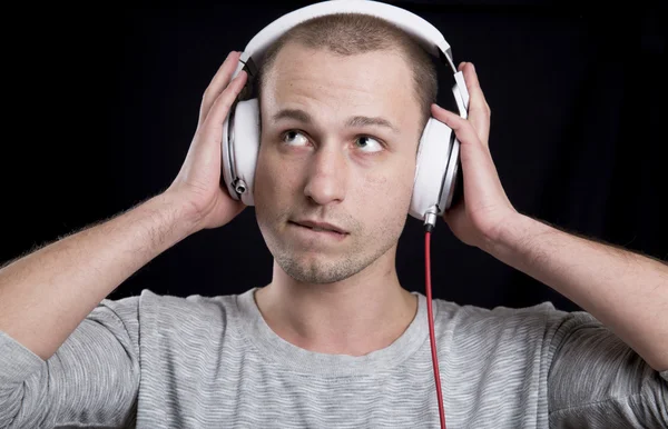 회색 티셔츠 헤드폰에서 음악을 듣고 있는 젊은이 — 스톡 사진