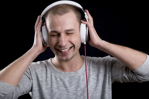 매력적인 남자 웃 고 헤드폰에서 음악을 듣고 — 스톡 사진