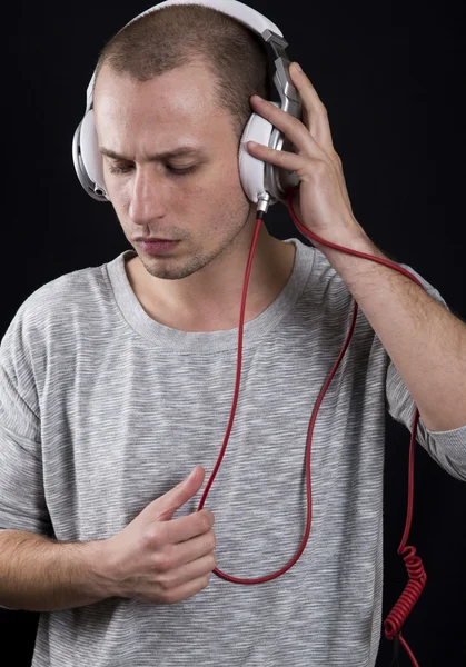 Atrakcyjny młody człowiek go słuchać muzyki na słuchawkach — Zdjęcie stockowe