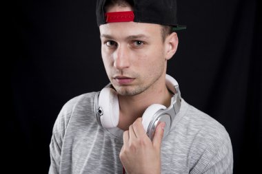  genç adam bir siyah kap ve kulaklıktan olan gri bir tişört 