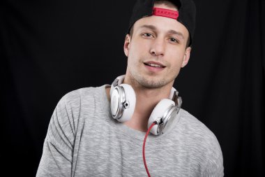 genç bir adam bir siyah kap ve kulaklıktan olan gri bir tişört