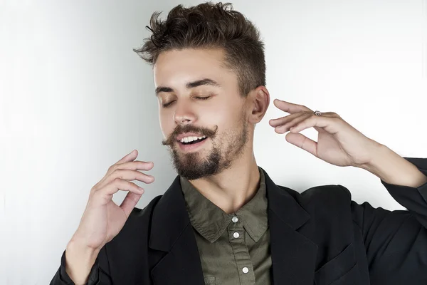 stylish man in a shirt in a beautiful pose smiles dreamily