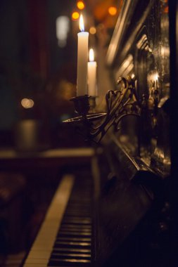 İki şamdanları siyah piyano duvarına bitişik mumlar 