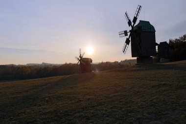 Adam orman yakınlarındaki küçük bir tepe üzerinde üç yel değirmenleri