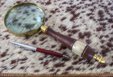 Büyüteç ve deri klasörde tükenmez kalem