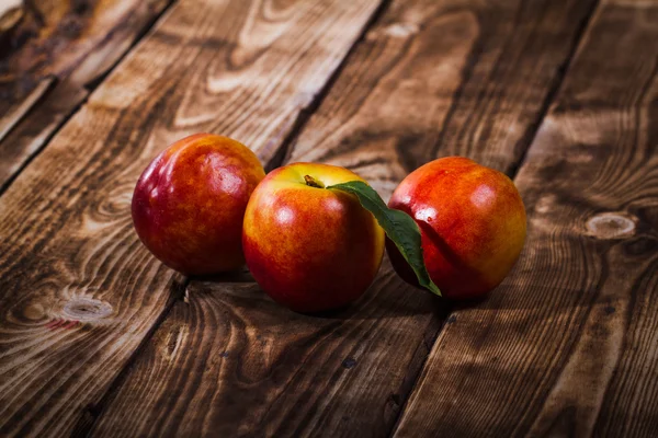 Perziken op een houten ondergrond — Stockfoto