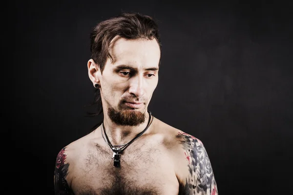 Portret van een man met naakte torso en tattooes — Stockfoto