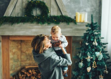 Sevimli anne ve çocuk Noel ağacının yanında iyi vakit geçiriyorlar.