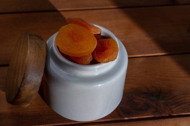 Ahşap masada kurumuş kayısı kasesi.