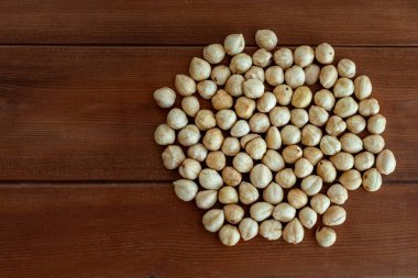 Ahşap masada kabuklu ve soyulmuş fındıkların üst görüntüsü.