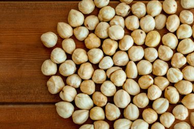 Ahşap bir masada kavrulmuş fındıklar üzerine saçılmış. Soyulmuş fındık. Yukarıdan görüntüle