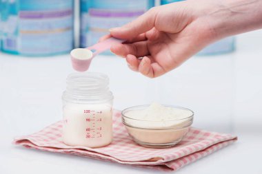 Beyaz masa arkaplanından beslenen bebek karışımı hazırlığı. Annem bir bebek maması hazırlıyor..