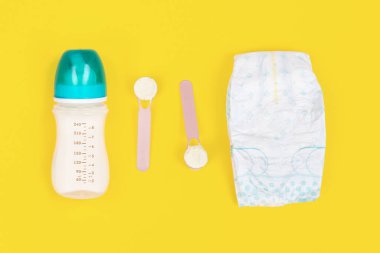 Çocuk bakım aksesuarları düzdü. Bebek besleme ve bebek bezi değiştirme kavramı. Üst görünüm