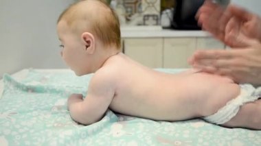 Terapist bir çocuğa sırt masajı yapıyor. Rahatlatıcı yeni doğmuş çocuk. Bebek masaj konsepti