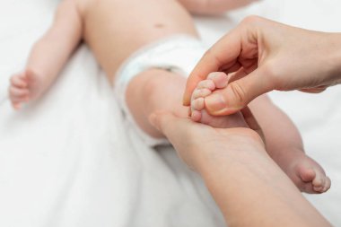 Anne bebeğinin ayaklarına masaj yapıyor. Anne ve çocuğu. Çocuk sağlığı konsepti ve rahatlama.
