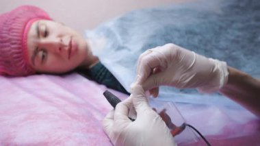 Dövme ustası işe hazırlanıyor. Güzellik uzmanı tek kullanımlık enstrümanları açar ve müşteriye gösterir. Kadınlar için kalıcı makyaj