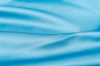 Gökyüzü mavisi güzel dalgalı ipek kumaş. Pürüzsüz, lüks kumaş dokusu. Soyut arkaplan tasarımı. Boşluğu kopyala