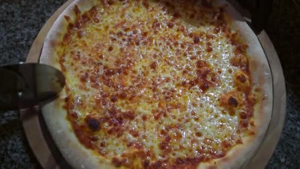 Kesiciyle pizzayı birden fazla dilime dilimleyen birinin yakın çekimi. Erkek ellerinin yakın plan pizza hamurunu kesmesi. Üst görünüm — Stok video