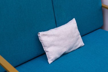 Mavi bir kanepede boş beyaz yastık. Kanepede Yastığın Yakın Çekimi.