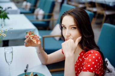 Genç bir kadın bruschetta yiyor. Şehvetli kız. Bruschetta ile seksi, güzel bir model.. 