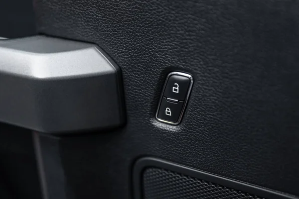 Car door lock unlock button close up. Electric central locking button in modern car. Selective focus.