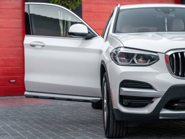 Açık yolcu kapısı olan beyaz renkli modern SUV arabasının ön görüntüsü