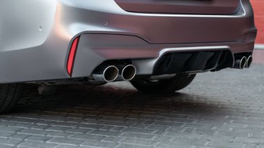 Modern araba iç mimarisi. Çift egzoz borusu olan yeni spor arabayı kapat. Egzoz borusu ve arabanın arka kısmı..