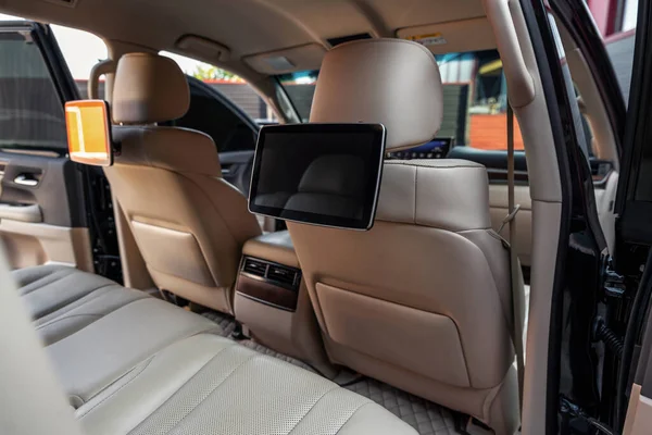 Carro dentro. Telas multimídia ou monitores de TV para bancos traseiros de passageiros. Interior de carro de luxo com assentos de couro — Fotografia de Stock