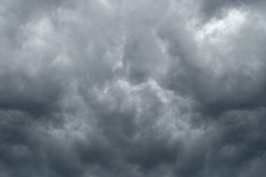 Karanlık gökyüzünde kara fırtına bulutları olan dramatik bir arka plan. Yağmurdan önce kara bulutlar