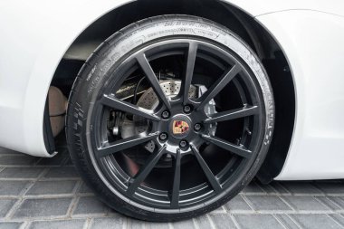 Ukrayna, Odessa 8 Eylül 2021: Siyah kenarlı bir disk ve frenleri delinmiş bir Porsche Boxter için ortada bir marka işareti. Michelin lastikli Porsche alaşım tekerleği.