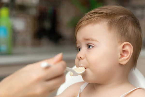 Pequeno menino caucasiano com a mão fechada a boca não comer a sua comida. Miúdo com cara suja e suja sentado em cadeira alta. Tempo de alimentação Fotografias De Stock Royalty-Free
