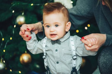 Noel ağacının güzel ışıkları karşısında papyon ve gömlek takan komik çocuk. Yılbaşı Xmas çocuğu. Noel arifesi tatili Noel gelenekleri.