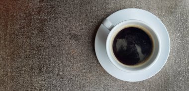 Grunge arka planında beyaz kahve fincanı veya sağında fotokopi alanı olan bir masa. Sabahları kafeteryada sıcak su içerek yatıyordu..