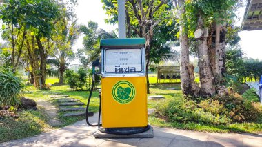 Bangkok, Tayland - 25 Aralık 2020: Sarı ve yeşil antika benzin veya patika ve bahçe arka planı olan benzin istasyonu. Retro veya Eski teknoloji nesnesi.