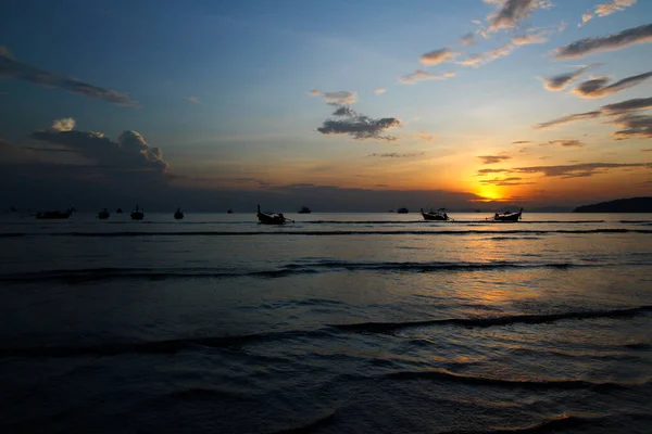 タイのクラビで日没 日の出 夕暮れ時に青い空と雲と海や海に船や長い尾のボートの美しいシルエット 波と交通の概念を持つ自然の美しさ — ストック写真